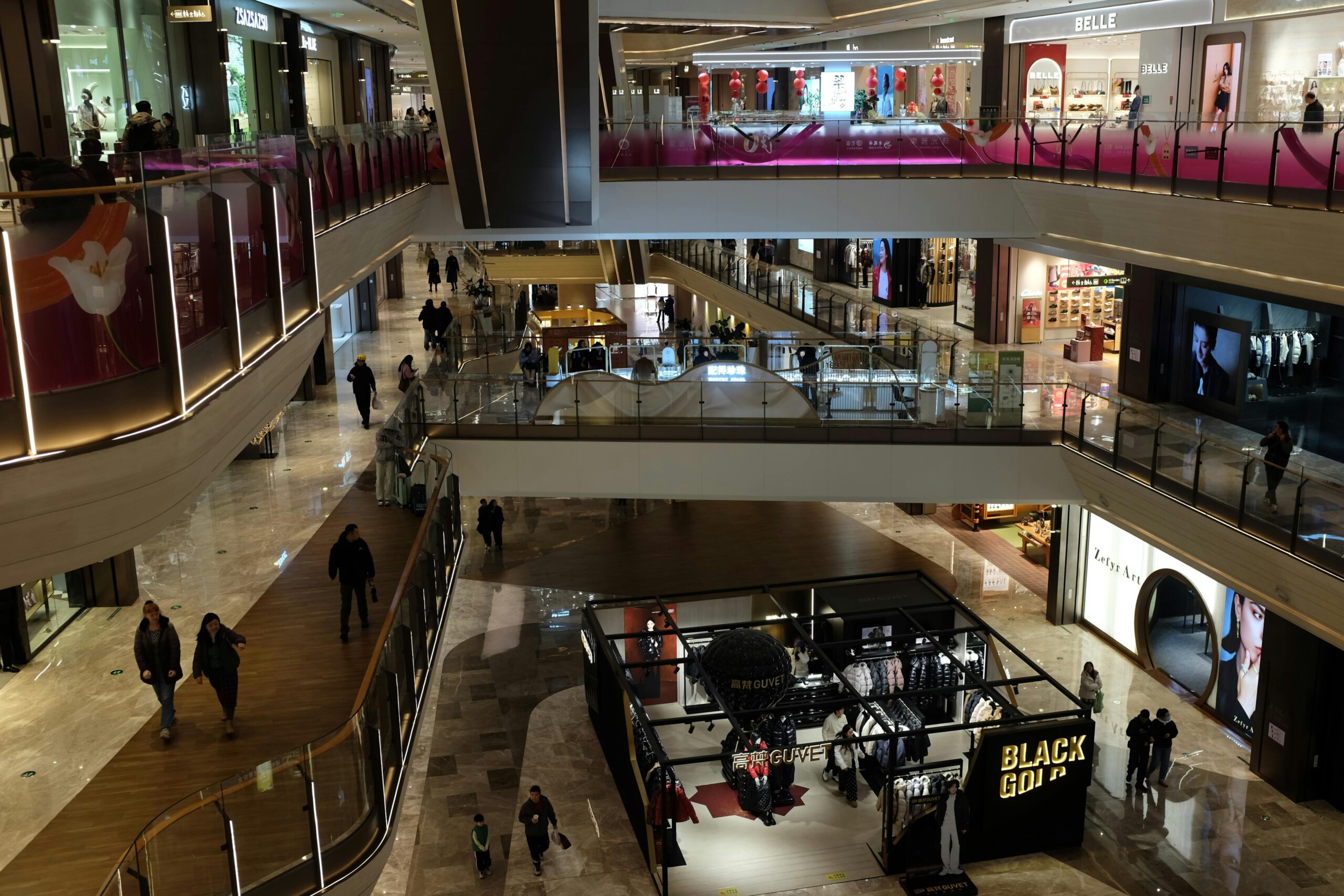 Spacious indoor mall with elegant design, featuring various shops and escalators.